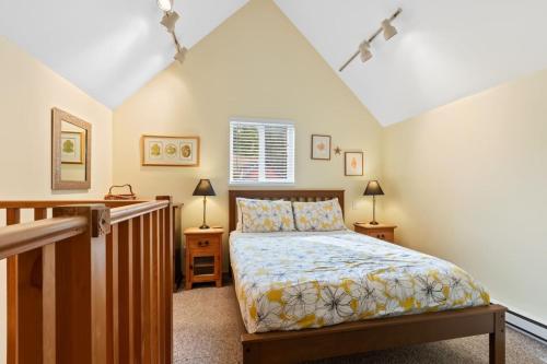 ein Schlafzimmer mit einem Bett und zwei Nachttischen in der Unterkunft Tyee Retreat Cozy Lofted 1 Bedroom Cabin in Ucluelet