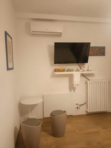 a living room with a tv and a table and stool at B&B SAN FRANCESCO Pescara Centro in Pescara