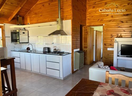 a kitchen with white cabinets and a stove at Cabaña Lucio in Esquel
