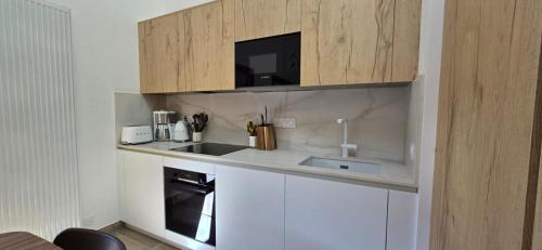 une petite cuisine avec un évier et un micro-ondes dans l'établissement Au Beau Séjour, à Samoëns