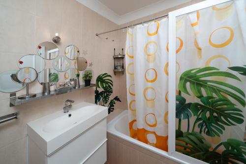 a bathroom with a sink and a shower curtain at Casa Paraiso - stylish gateway in Carvoeiro
