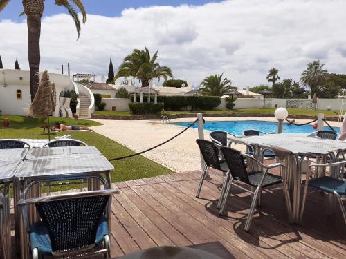 a patio with a table and chairs next to a pool at Villa Blue - Aldeia do Golfe in Quarteira