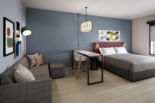 a bedroom with a bed and a couch at Atwell Suites Corpus Christi Southeast by IHG in Corpus Christi