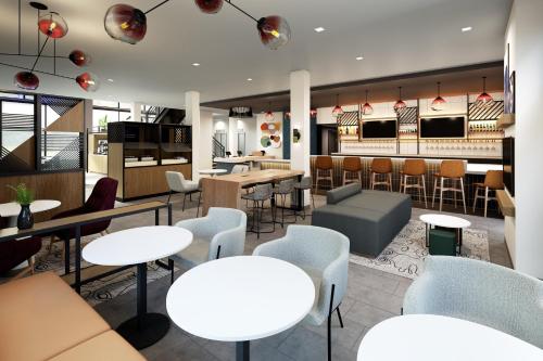 a restaurant with tables and chairs and a bar at Atwell Suites Corpus Christi Southeast by IHG in Corpus Christi