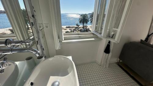 a bathroom with a sink and a window with the beach at Riva Luxury Suites in Split