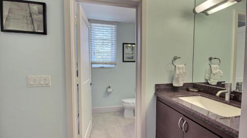 a bathroom with a sink and a toilet and a mirror at 131 Mariners Club in Key Largo