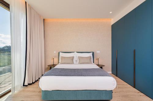 a bedroom with a large bed and a large window at Haven Nature Hotel & Villas in Batalha