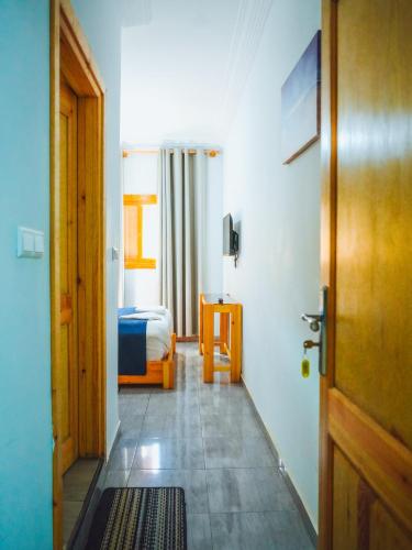 a room with a bedroom with a bed and a door at Fyndy Hotel Dakhla in Dakhla