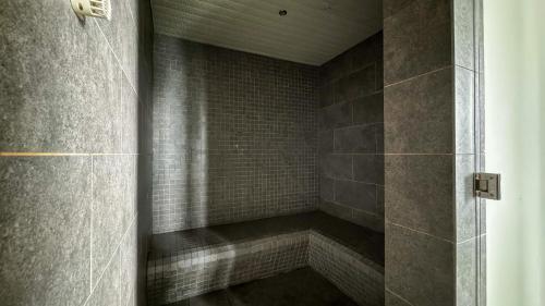 um chuveiro com parede de azulejos em Seabreeze 1BR Suite with Gorgeous Infinity Pool em Kuala Lumpur