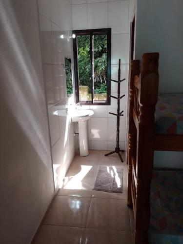 a bathroom with a sink and a tub and a window at Suites Brejauva in Ubatuba