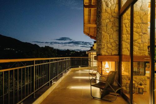 a balcony with a chair and a fireplace at Mirante da Colyna Hotel & SPA in Monte Verde