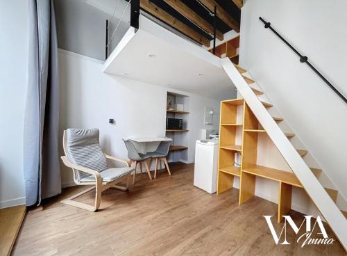 une pièce avec un escalier, une table et des chaises dans l'établissement Appart Chaleureux gare de Oullins 2, à Oullins