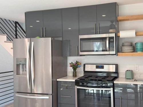 a kitchen with a stainless steel refrigerator and a microwave at Chic, Cozy & Comfort Modern Room in Austin