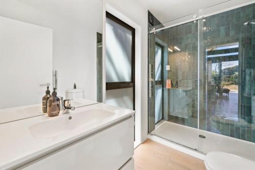 a bathroom with a sink and a glass shower at The Cabin - Holiday home in Wellington