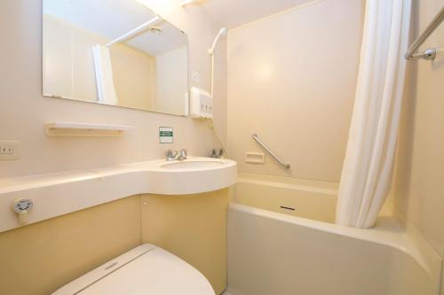 W łazience znajduje się toaleta, umywalka i lustro. w obiekcie Yonago Washington Hotel Plaza w mieście Yonago
