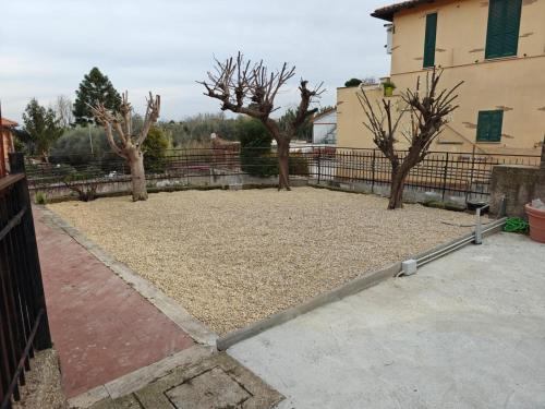 a yard with trees and a fence and a building at LA CASETTA NELLA MACCHIA di BENEDETTA in Rome