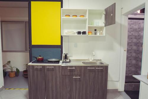 a kitchen with wooden cabinets and a sink in it at Laureles Garden Hostel in Medellín
