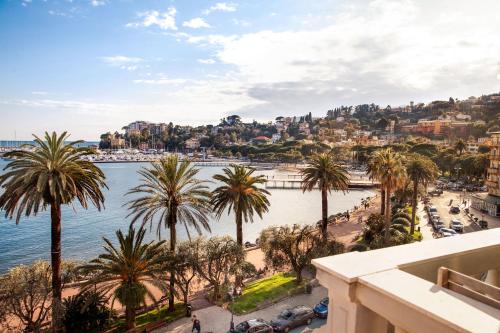 a view of a river and palm trees from a building at Hotel Vesuvio in Rapallo