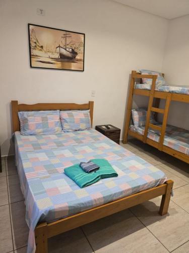 a bedroom with a bed and two bunk beds at Pousada ENCANTOS DO MAR in Ubatuba