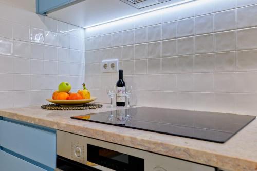 a kitchen counter with a bowl of fruit and a bottle of wine at New flat and central in Lisbon