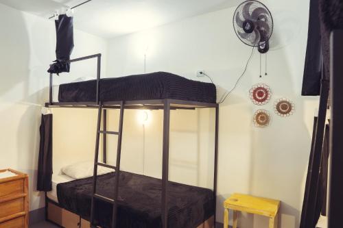 a bunk bed in a room with a fan at Laureles Garden Hostel in Medellín