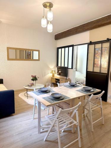 un salon avec une table et des chaises de salle à manger dans l'établissement Le COSY NÎMOIS, charme et terrasse au cœur de Nîmes, à Nîmes