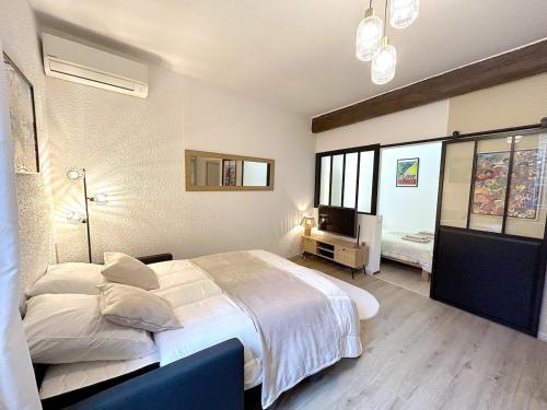 une chambre avec un grand lit blanc et une fenêtre dans l'établissement Le COSY NÎMOIS, charme et terrasse au cœur de Nîmes, à Nîmes