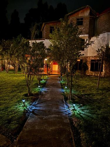 a walkway with lights in a yard at night at Hotel El Rancho in Concepción