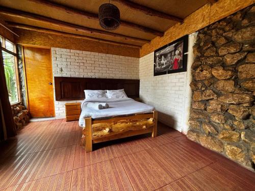 a bedroom with a bed in a stone wall at Hotel El Rancho in Concepción