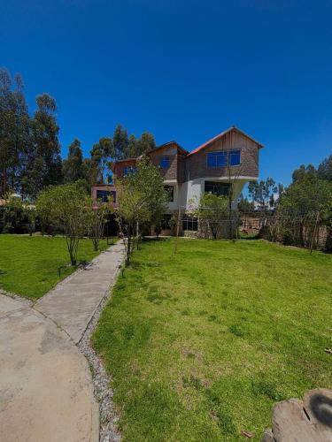 a house on a hill with a green yard at Hotel El Rancho in Concepción