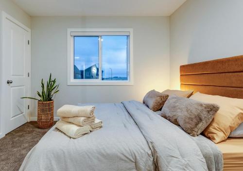 YYCにあるNeutral Living 6Beds 4Bedrooms and Bonus Room Free Parkingの窓のある大きなベッドのある寝室