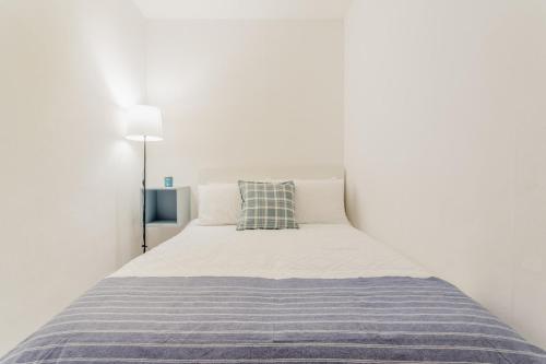 a white bedroom with a bed with a blue blanket at SEASlDE Beachfront 4 BDR by Casa Paraiso in Cancún