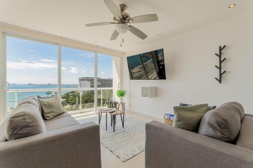 a living room with two couches and a large window at SEASlDE Beachfront 4 BDR by Casa Paraiso in Cancún