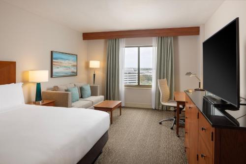 a hotel room with a bed and a desk with a television at Hilton St. Petersburg Carillon Park in St Petersburg