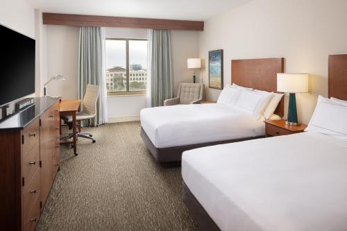 a hotel room with two beds and a desk at Hilton St. Petersburg Carillon Park in St Petersburg