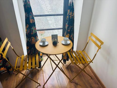 a small table and chairs in a room with a window at Techas City Center Luxurious Suite in Praia