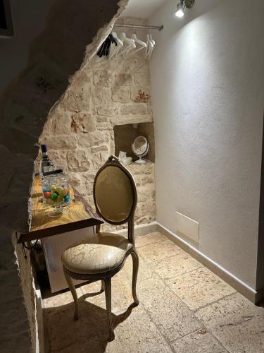 a chair in a room with a stone wall at Murantiche in Putignano