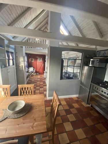 a dining room with a wooden table and a kitchen at Kleiner-Mann in Rysum