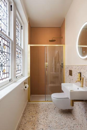 a bathroom with a shower and a toilet and a sink at FiveM West Hampstead - South in London