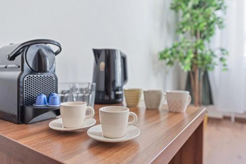 a wooden counter with three cups and a coffee maker at K22 Smart Rooms in Vienna