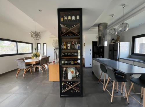 une cuisine et une salle à manger avec un casier à vin dans l'établissement Villa ANAVI - maison 4 chambres et piscine, à Saint-Caprais-de-Bordeaux