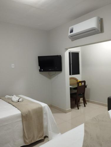 a white room with a bed and a tv on the wall at Apartamento recanto paz in Teresina