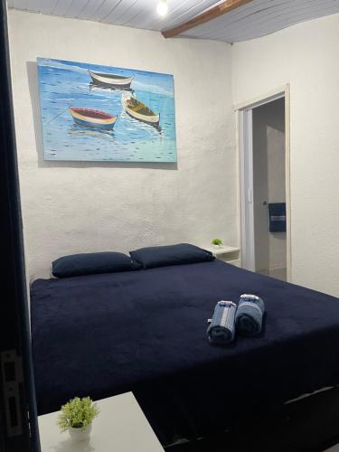 a bedroom with a bed with two boats on it at Primos Hostel & House in Búzios