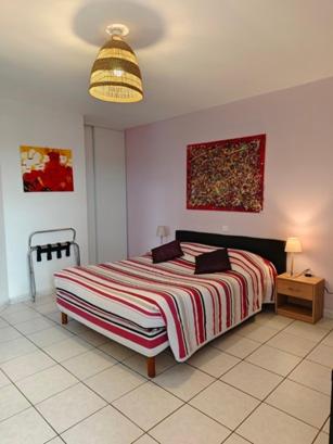 une chambre avec un lit avec une couverture rayée dans l'établissement Le Grand Jardin, à Aujargues