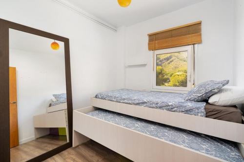 a small bedroom with a bed and a mirror at Beautiful flat in Castelldefels in Castelldefels