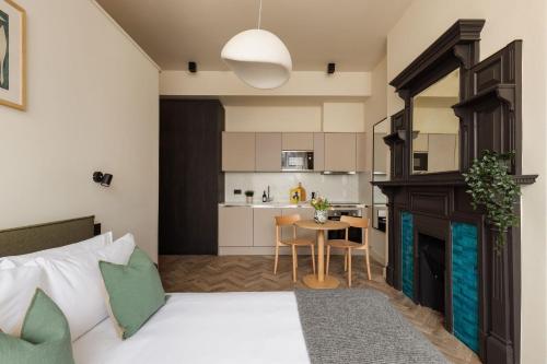 a bedroom with a bed and a kitchen with a table at FiveM West Hampstead - South in London