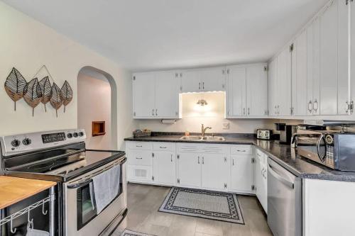 a kitchen with white cabinets and white appliances at Gorgeous 3 bedroom home, minutes from Lambeau! in Green Bay