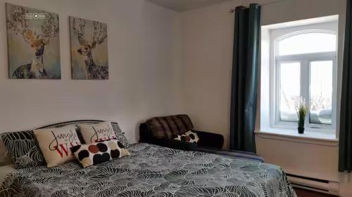un dormitorio con una cama y una ventana en Cozy Suite #3 in the Heart of DT Quebec with QB, en Quebec