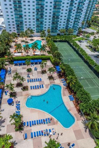 an aerial view of a resort with a pool and tennis courts at Trendy 1BD Condo 4 Mins to Beach in Sunny Isles Beach