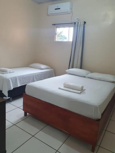 two twin beds in a room with a window at Hotel Rilton in Carolina